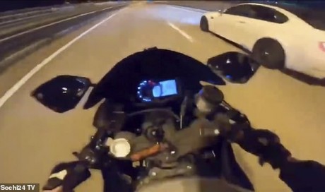 Woman biker\'s 120mph crash is caught on her helmet camera as she cheats death and suffers just cuts and bruises while street racing a car in Russia